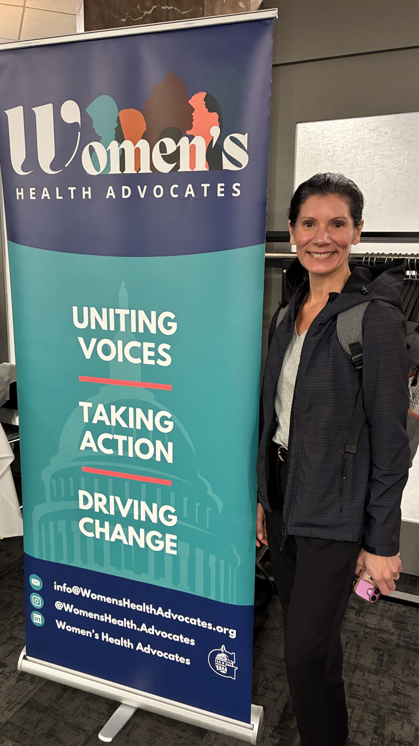 Michelle beside the Women’s Health Advocates banner Michelle beside the Women’s Health Advocates banner